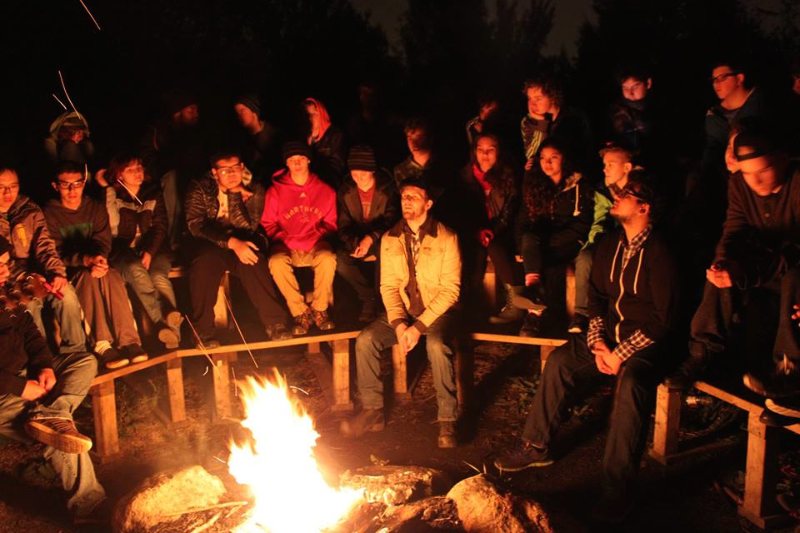 YMCA Academy students singing songs around the campfire at Cedar Glen