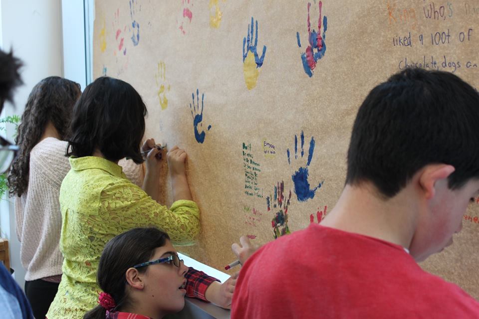 YMCA Academy students create a Handprint Mural with the guidance of Jim Adams.
