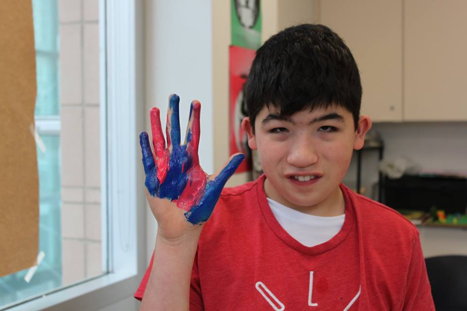 YMCA Academy students create a Handprint Mural with the guidance of Jim Adams.