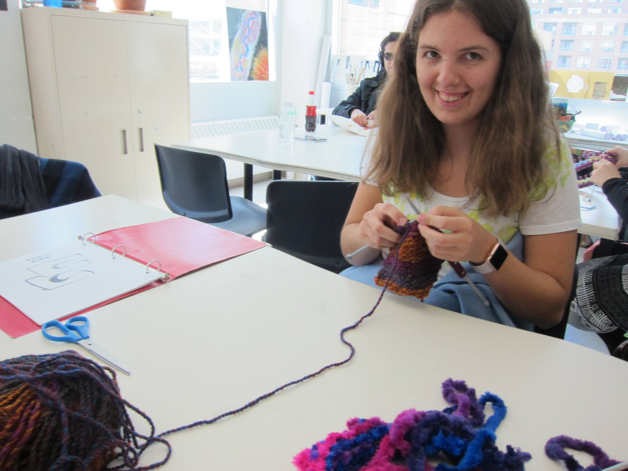 YMCA Academy students knit with a volunteer.