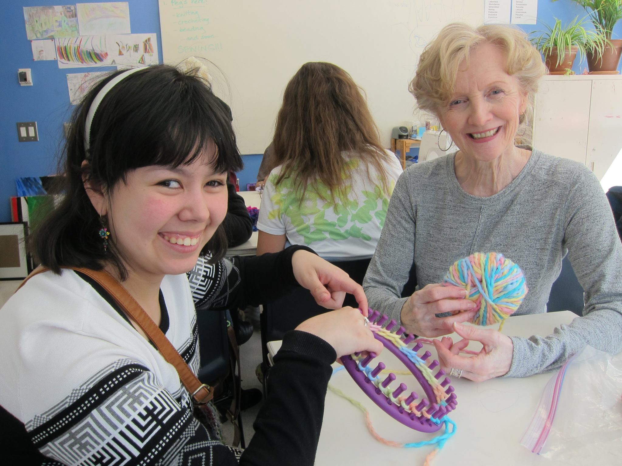 YMCA Academy students knit with a volunteer.