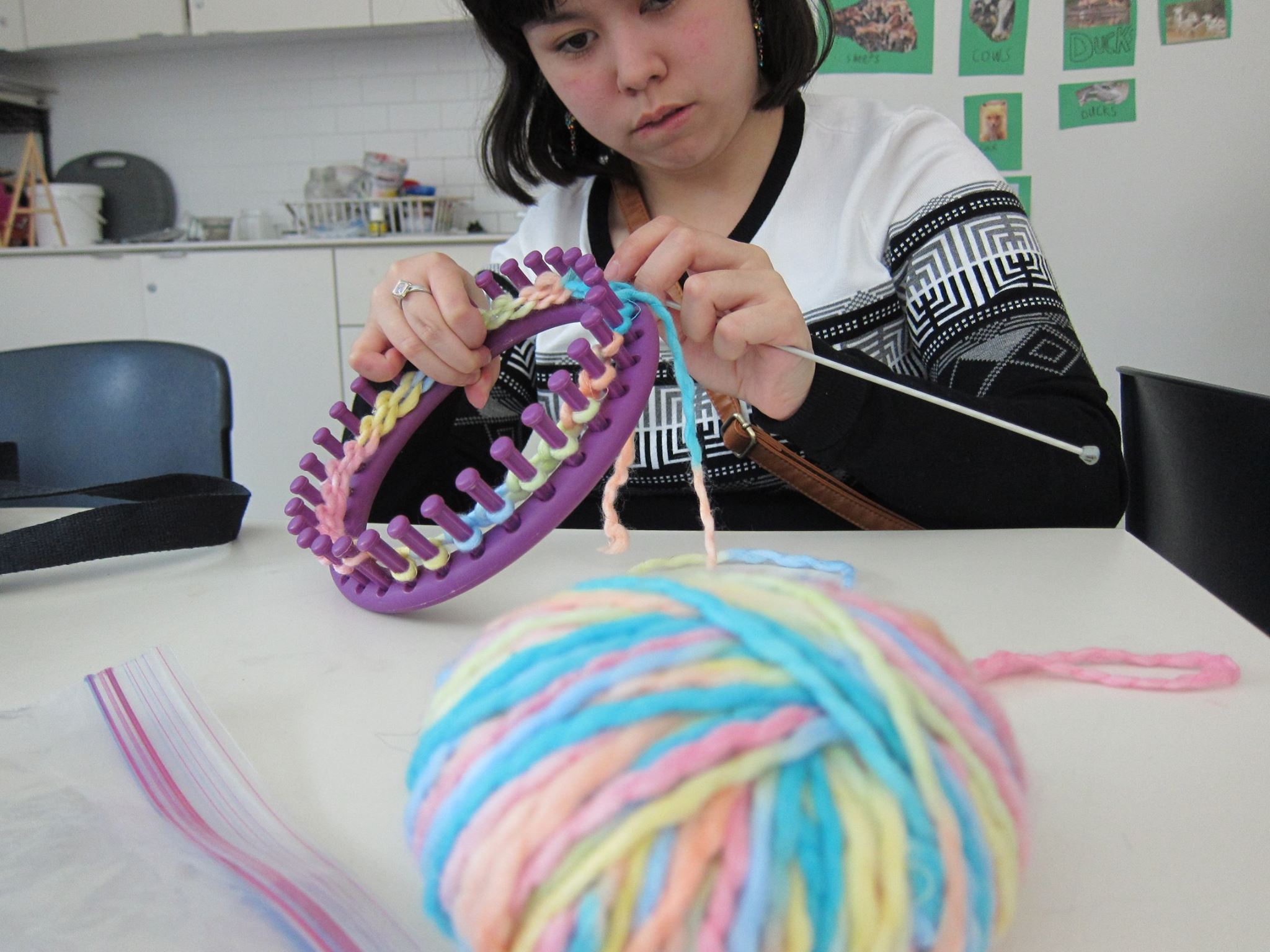 YMCA Academy students knit with a volunteer.