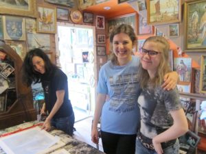 YMCA Academy fashion class students, with Kingi Carpenter, use a silk screening process to design shirts and other materials.