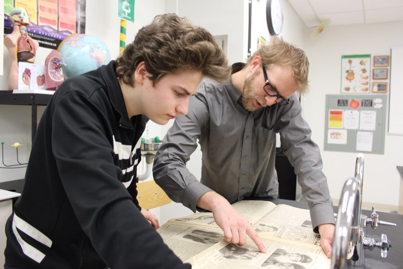 YMCA Academy Grade 10 Canadian History students excitedly crowded around a Montreal Star newspaper dated August 11th, 1943