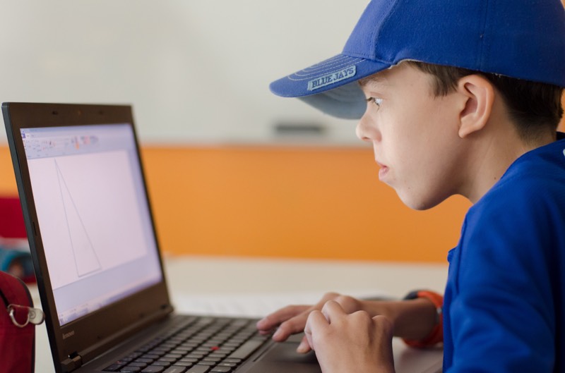 YMCA Academy student using in-class assistive technology on a laptop.