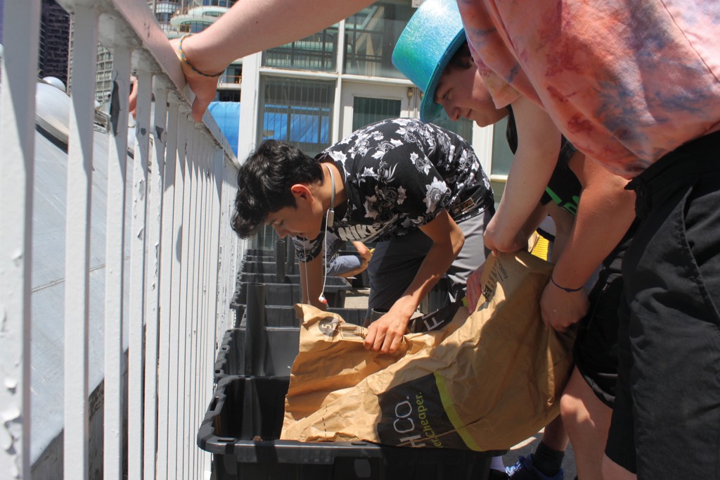 Academy students prepare the community garden with soil