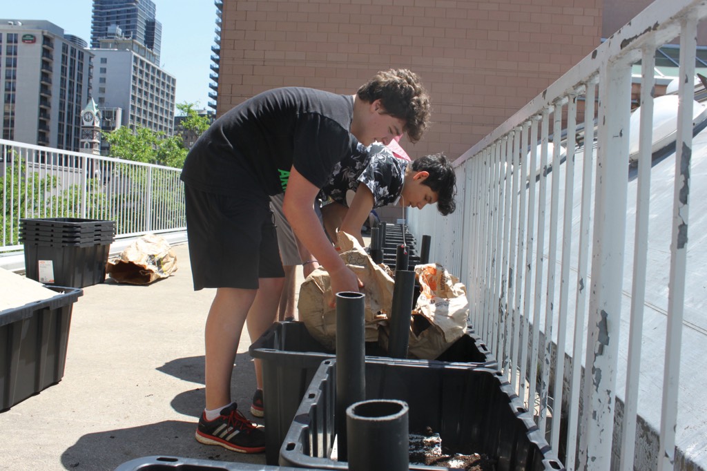 Academy students prepare the community garden with soil