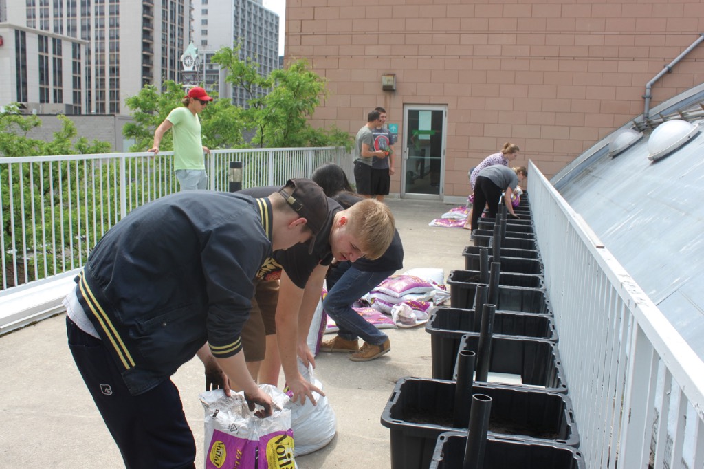 Academy students prepare the community garden with soil