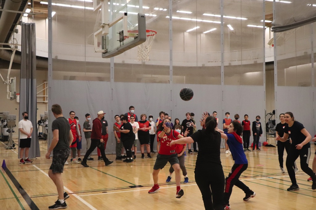 This day included fun activities such as designing a Toronto Raptors logo, slogan, or poster, and participating in “blindfolded basketball,” where the students used teamwork to help their classmates score a mini basket.