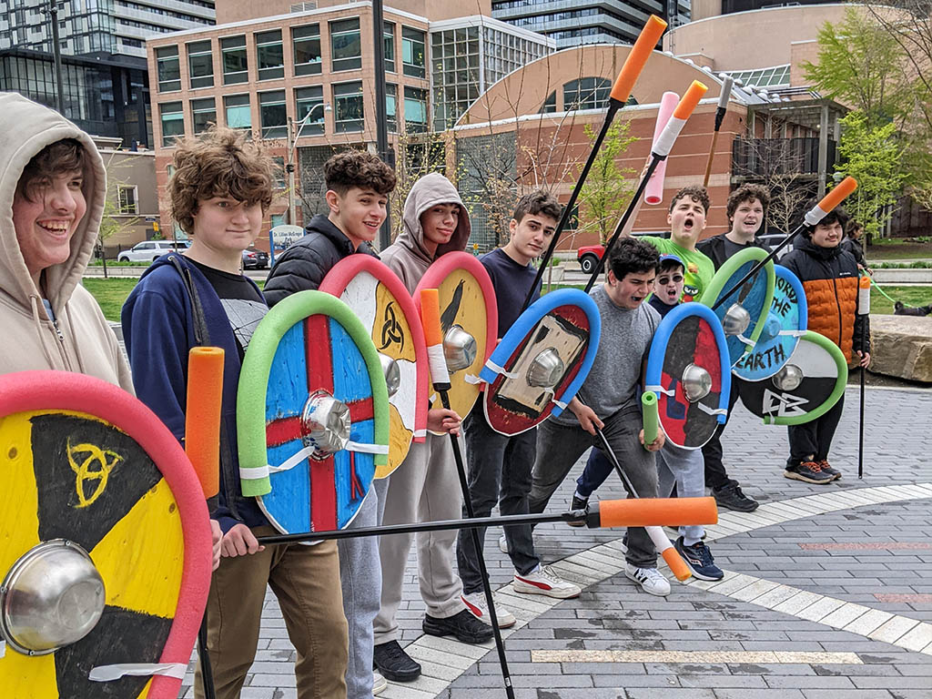 The Grade 12 Adventures in World History class engaged in some hands-on-experiential learning in the park near YMCA Academy. Students have been learning about the adventures of Norwegian, and Danish societies of the Viking Age roughly one thousand years ago.