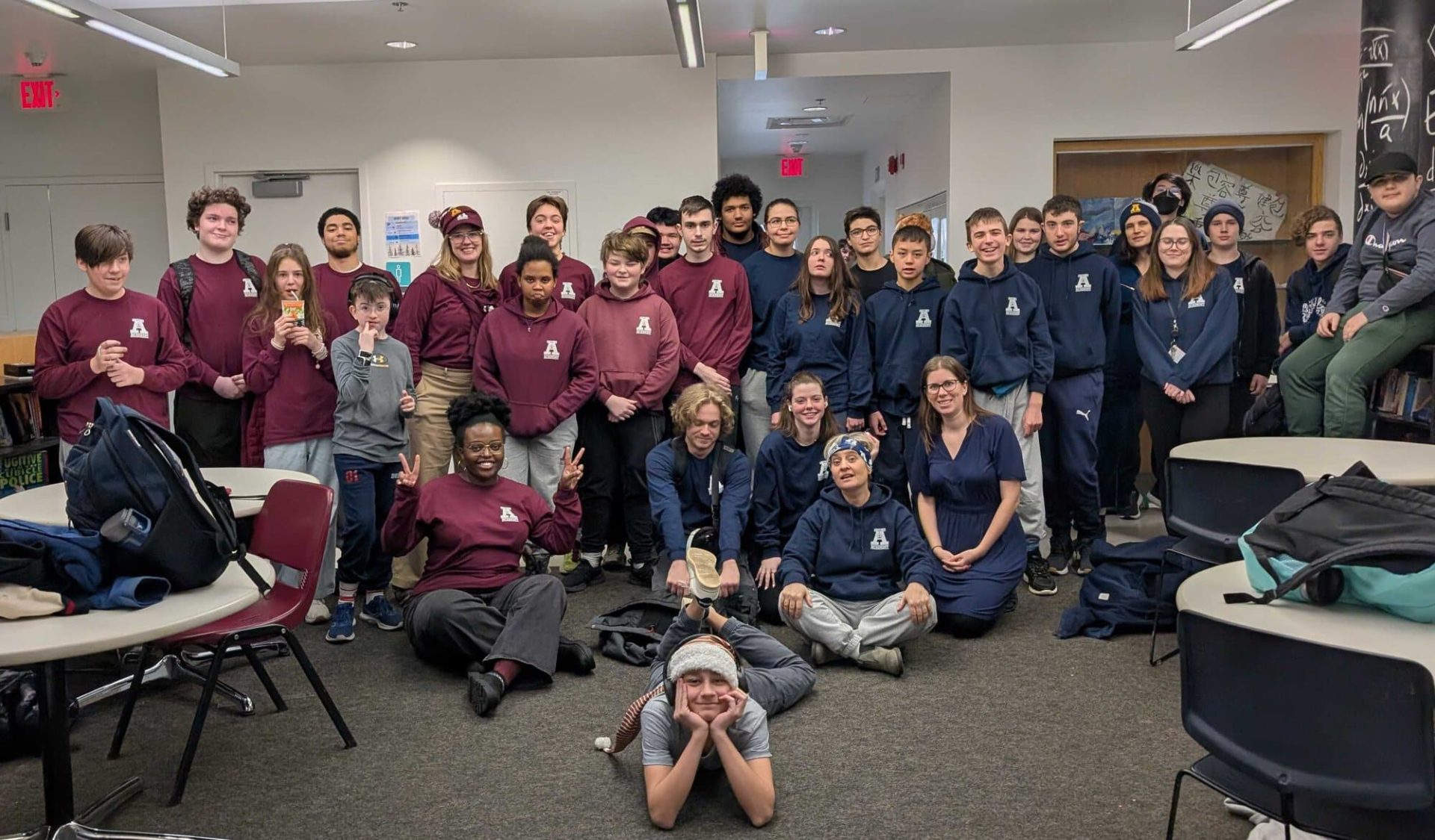 Group of diverse students and staff at YMCA Academy classroom.