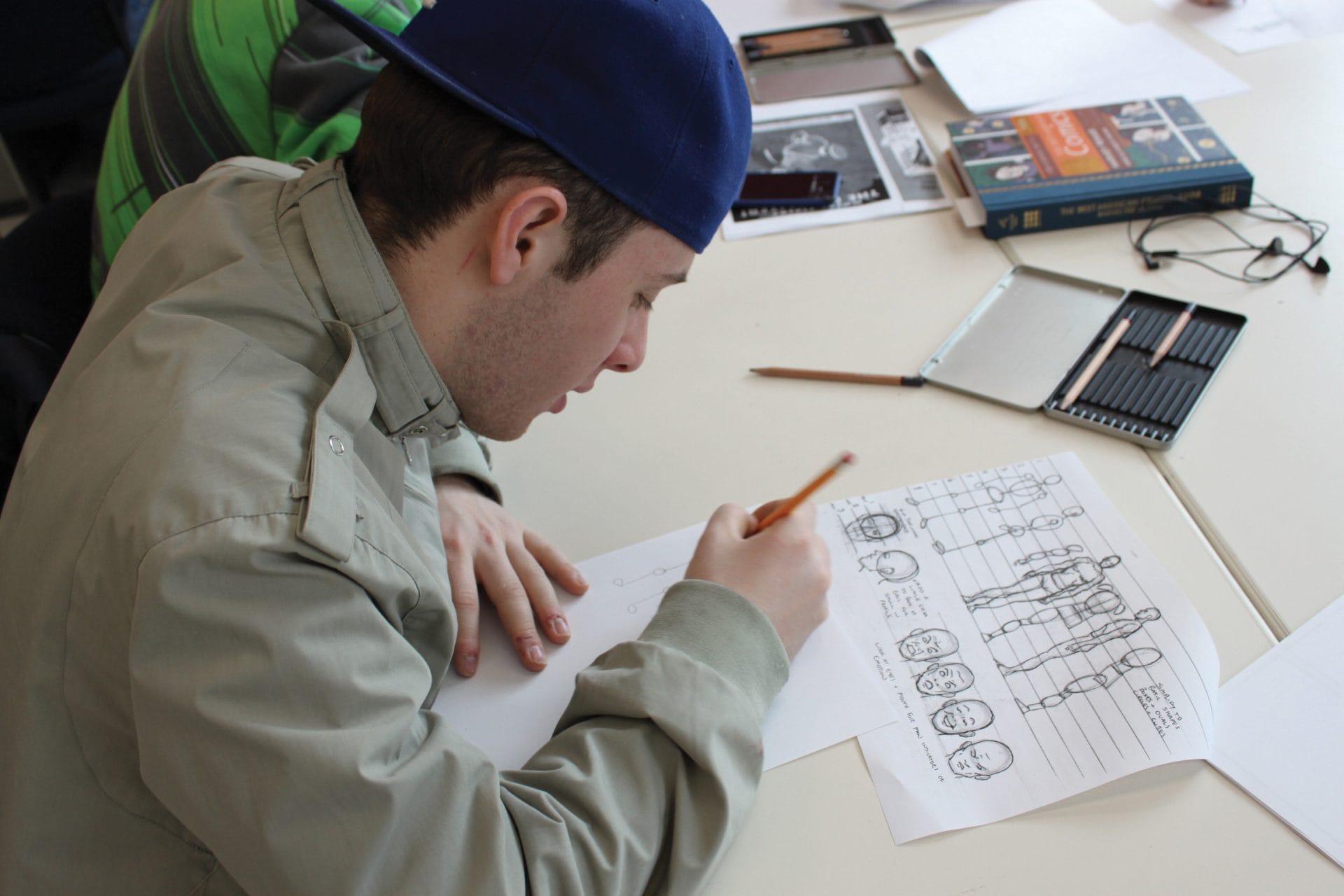 Student drawing technical sketches at YMCA Academy for educational development.