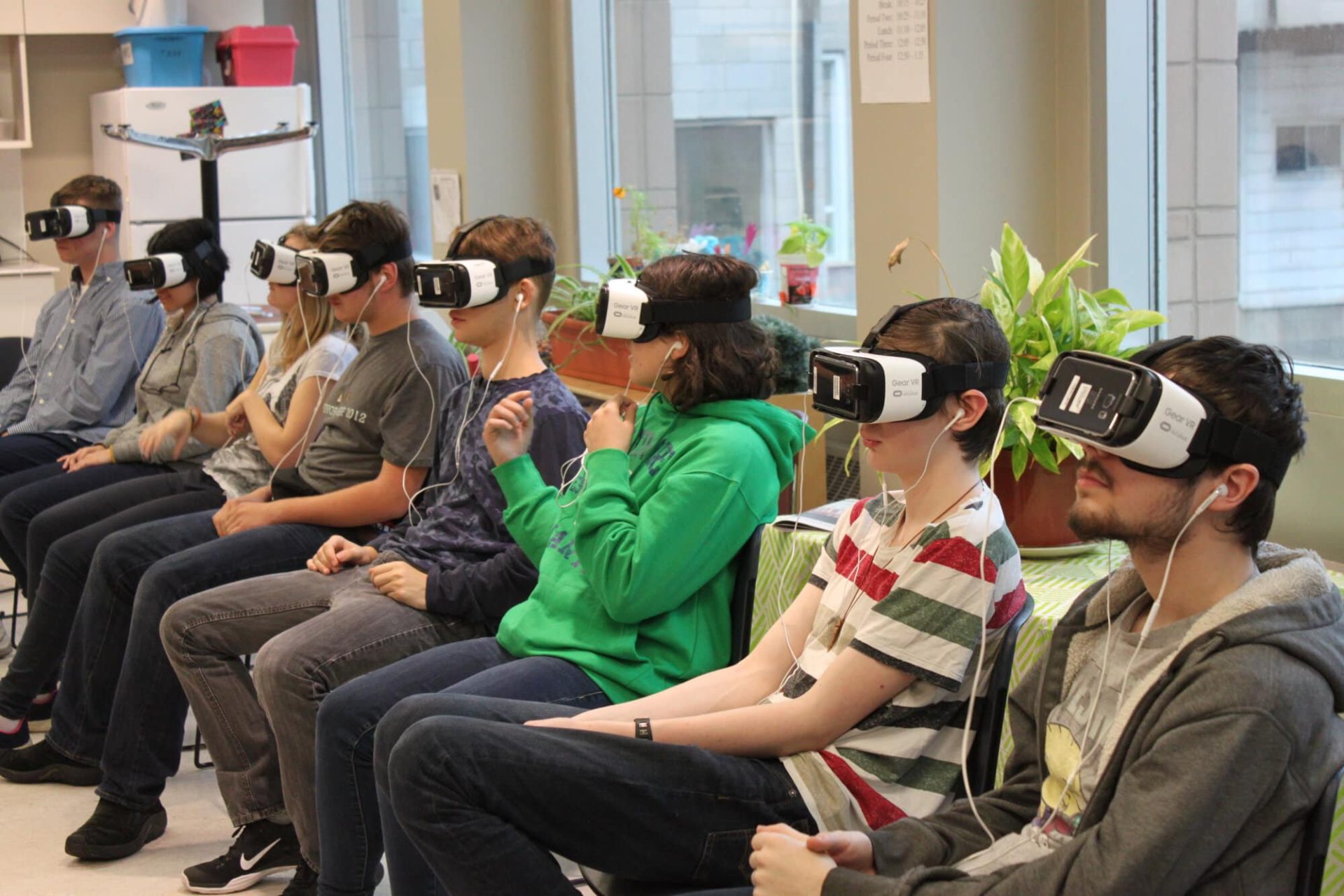 Students using VR headsets at YMCA Academy for immersive learning.