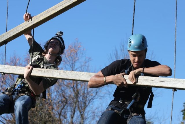 Children participating in outdoor adventure activities at YMCA Academy.