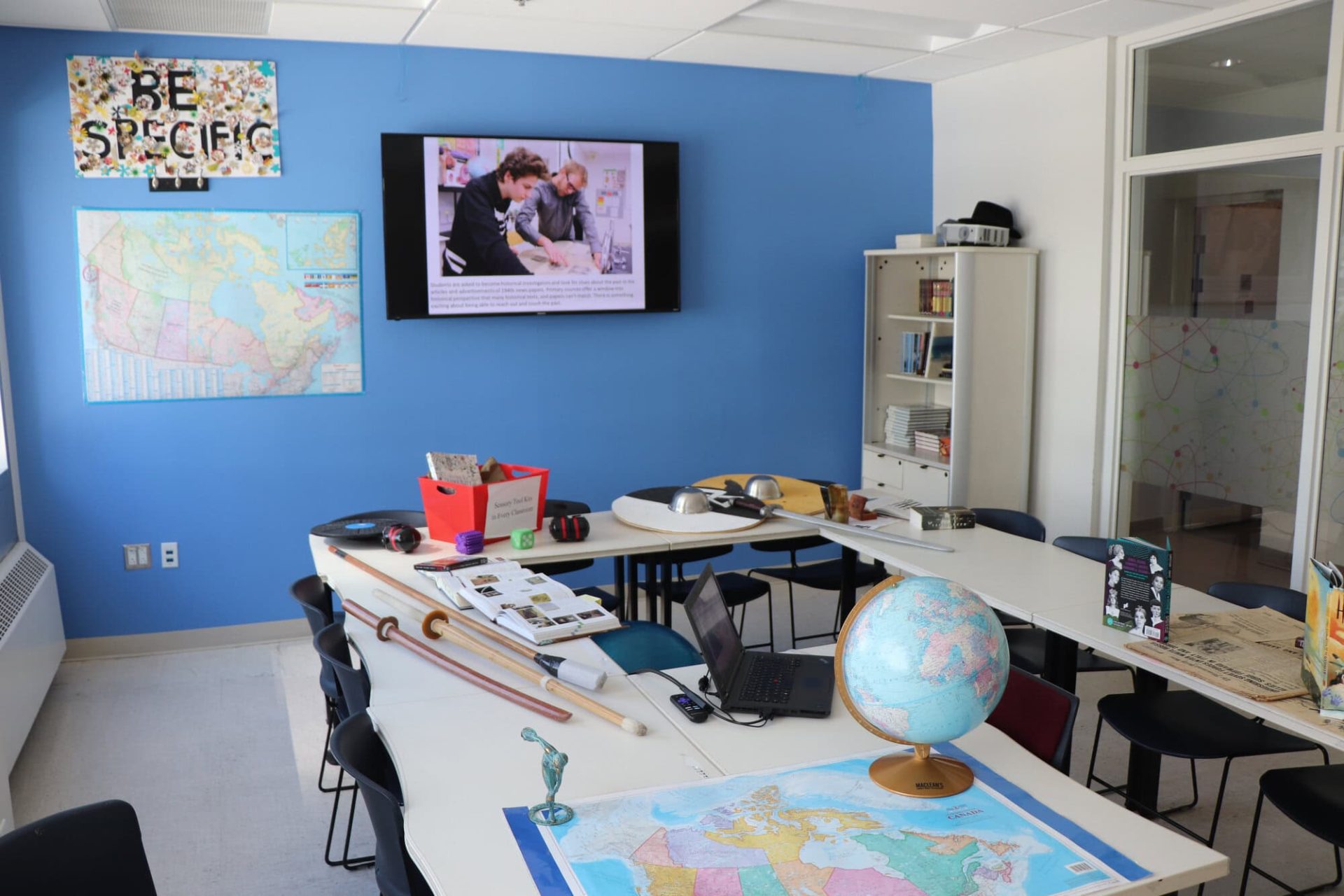 Classroom with tables, chairs, and educational materials at YMCA Academy.