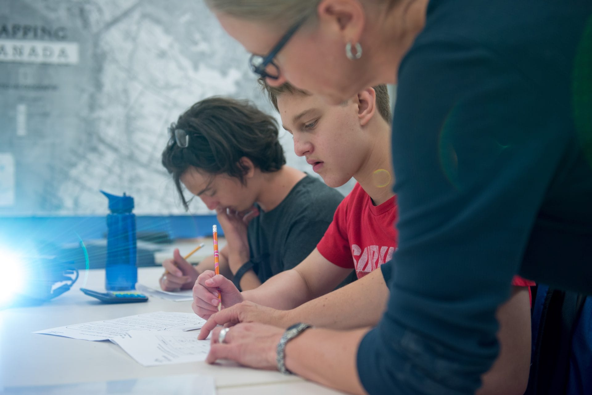 Students engaged in learning with teacher at YMCA Academy.