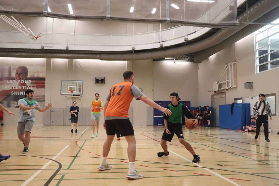 Young players practicing basketball at YMCA Academy gym.